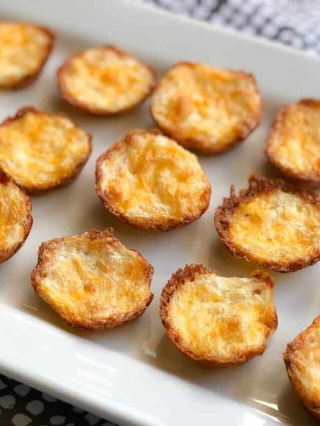 A white rectangular plate with several golden-brown, mini cheese and egg quiche bites crafted with a light cauliflower crust.