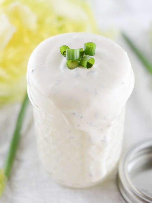 ranch dressing in mason jar with ranch spilling over the edge.