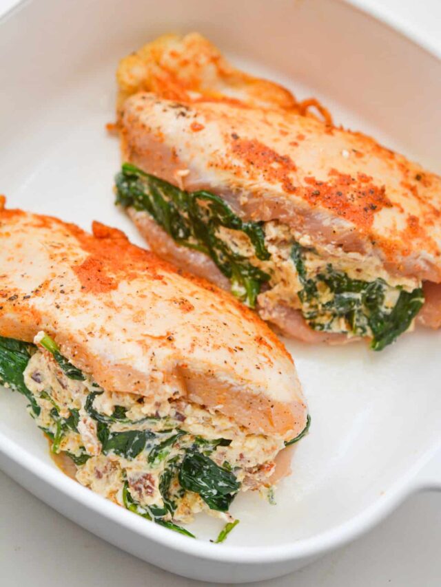 Two Spinach-Stuffed Chicken breasts filled with a creamy feta cheese mixture, displayed in a white baking dish.