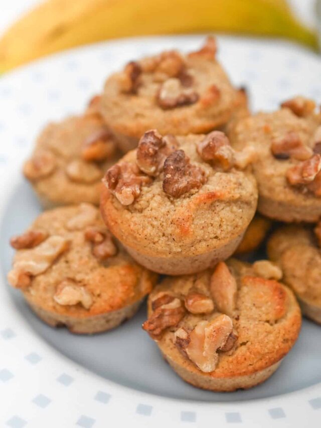 A plate of freshly baked banana muffins topped with chopped nuts.